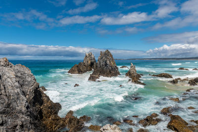 Scenic view of rocks in sea against sky