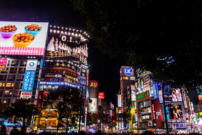 Low angle view of neon posters on buildings at night