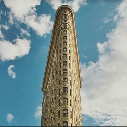 Low angle view of modern building against cloudy sky