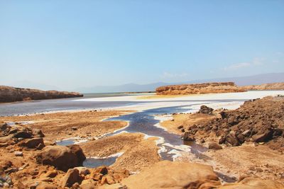 Scenic view of beach against clear blue sky