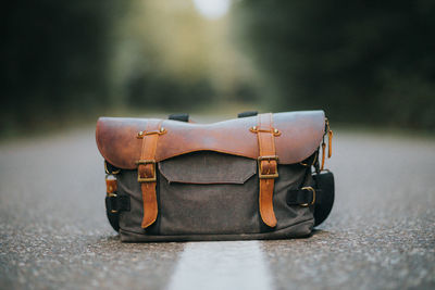 Close-up of messenger bag on road