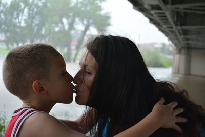 Mother and son kissing during rainy season