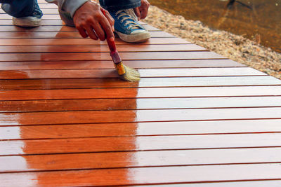 Low section of man standing on boardwalk