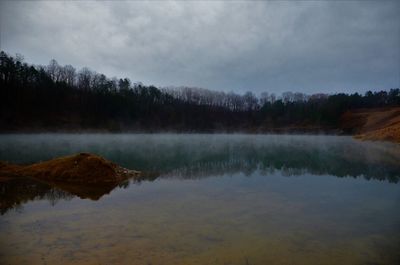 Scenic view of lake in forest against sky