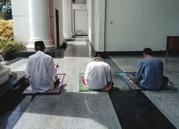 Rear view of people sitting outside building