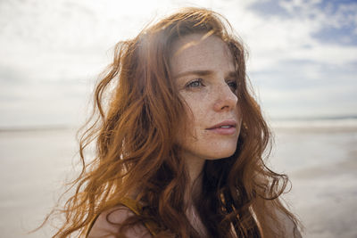 Portrait of a redheaded woman on the beach