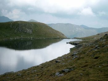 Scenic view of lake against cloudy sky