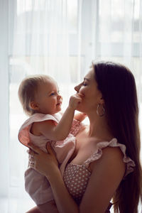 Side view of mother and daughter at home