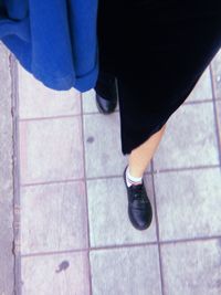 Low section of woman standing on tiled floor