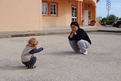 Full length of mother and daughter playing outside house