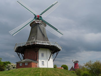 Low angle view of traditional windmill against sky