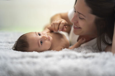 Mother playing with her baby in bed