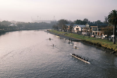 High angle view of boats in river against buildings