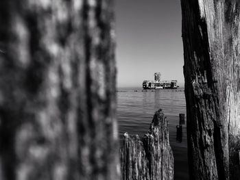 Distance shot of boat in calm sea against clear sky