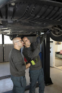 Two car mechanics working in garage