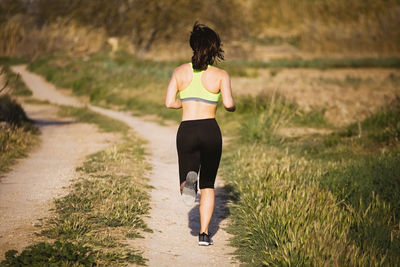 Rear view of woman running on land