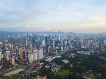 Petronas towers amidst cityscape against sky during sunset