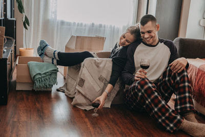 Friends sitting on sofa at home