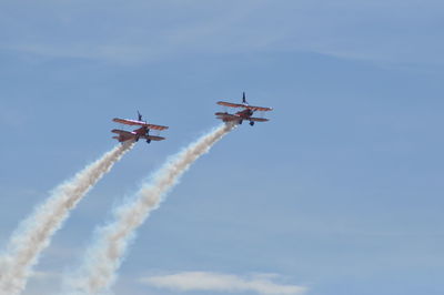 Low angle view of airshow against sky