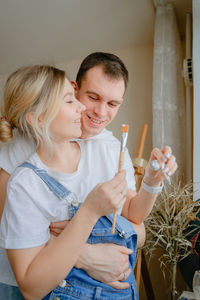 Portrait of smiling young woman blowing bubbles at home