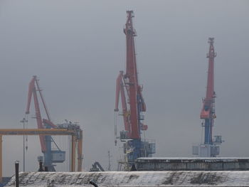 Cranes at construction site against sky