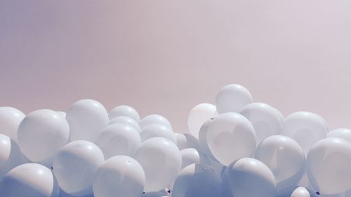 Low angle view of white balloons against clear sky