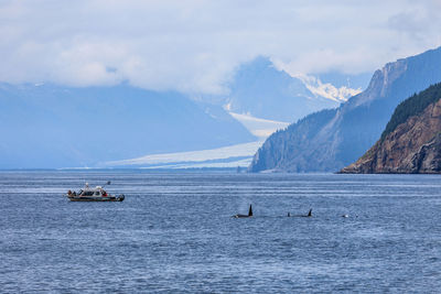Scenic view of sea and snowcapped mountains against sky