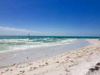 Scenic view of beach against blue sky