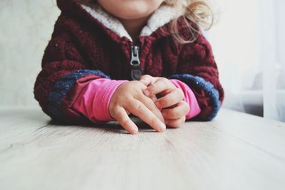 Midsection of baby girl leaning on table
