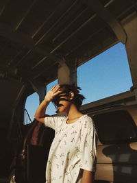 Young woman shielding face while standing in motor home
