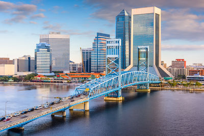 Bridge over river in city against sky