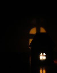 Close-up of illuminated lamp on table at night