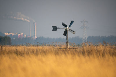 Windmill on field against sky