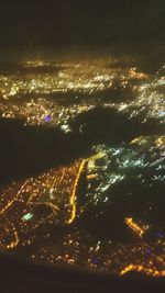 Aerial view of illuminated cityscape against sky at night