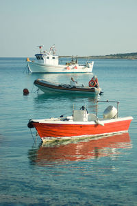 Boat moored in sea against clear sky