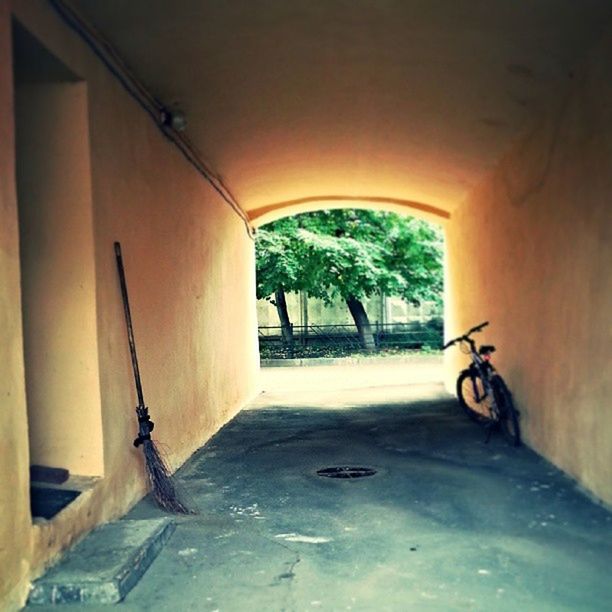 architecture, built structure, indoors, one person, the way forward, house, wall - building feature, wall, door, flooring, absence, empty, building exterior, bicycle, sunlight, building, corridor, window, day, shadow