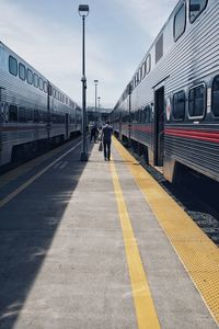 Rear view of train at railroad station against sky