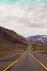 Road by mountain against sky