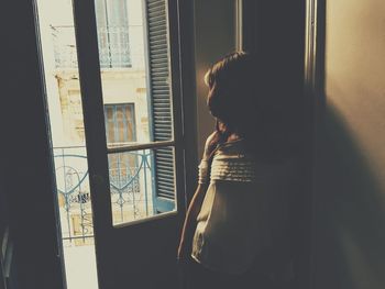 Woman wearing mask while standing at home