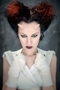 Digital composite image of horned young woman with make-up