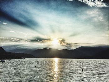 Sun shining through clouds over mountains