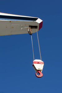 Low angle view of red light against clear blue sky