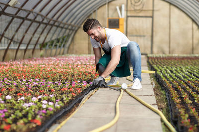 Full length of man working in greenhouse