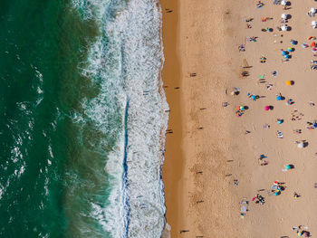 Vacationers fill praia princesa in lisbon
