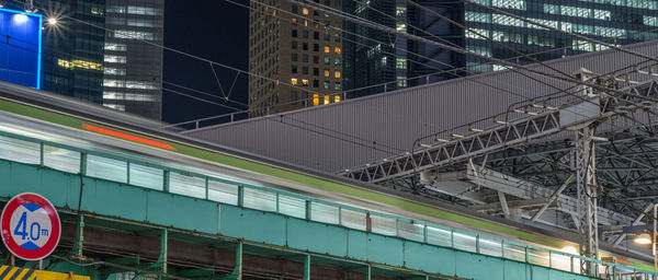 Low angle view of illuminated train in city at night