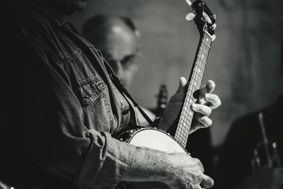 Midsection of man playing guitar during event
