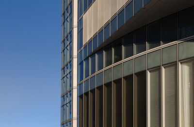 Low angle view of modern building in madrid, spain, against clear blue sky