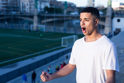 Portrait of young man standing in city