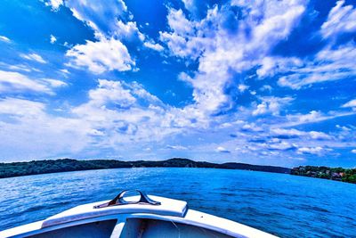 Boat in sea against cloudy sky