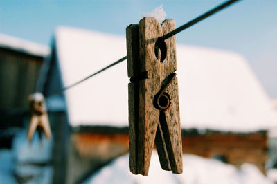 Close-up of clothespins on rope against sky